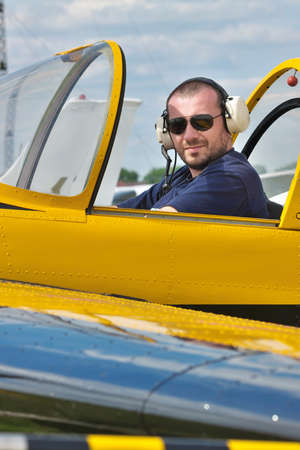Pilot of a small aerobatic plane sitting in the cockpitの写真素材
