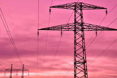 High voltage power lines against sunset skyの写真素材