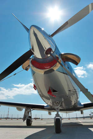 Propeller plane parked on the airfield - front close up view against the sun