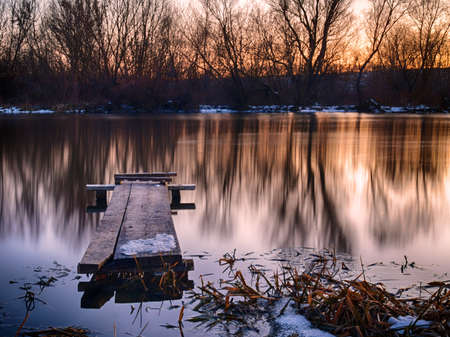 Sunset scene with a small river in winter eveningの写真素材