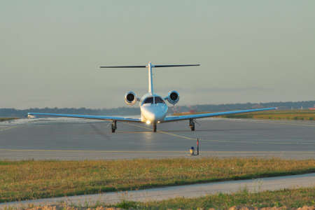 Private business jet taxiing along the runway to take off or after landing on sunsetのeditorial素材