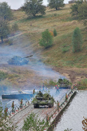 Zhitomir, Ukraine - September 29, 2010: Tanks cross the river over the pontoon ferry during the military trainingsのeditorial素材