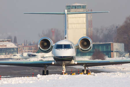 Business jet in the airport front view in winterの写真素材