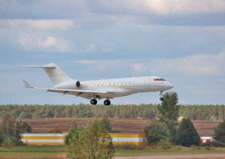 Business jet on short final landing with cloudy sky on the backgroundの写真素材