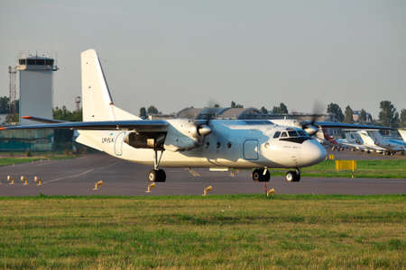 Kiev, Ukraine - July 27, 2012: Antonov An-24 regional turboprop passenger plane is taxiing along the runway before takeoff on sunsetのeditorial素材