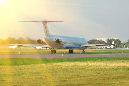 Passenger plane is taking off on sunsetの写真素材