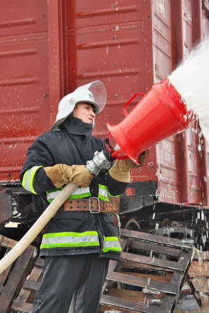 Chernihiv Region, Ukraine - January 14, 2011: Firefighter is covering the bus with foam after the...