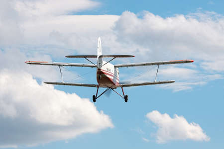 Kiev Region, Ukraine - September 28, 2010: Antonov An-3 biplane landing with cloudy sky on the background - rear viewのeditorial素材