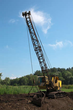 Excavator developing the peat on the swampの写真素材