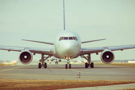 Passenger plane taxiing along the airport taxiwayの写真素材