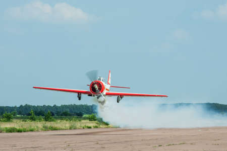 Zhitomir, Ukraine - June 17, 2011: Yakovlev Yak-52 aerobatic plane passing low over the runwayのeditorial素材