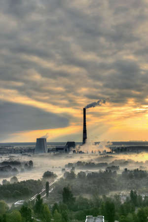 Sunrise over the power station with fog in the valleyの写真素材
