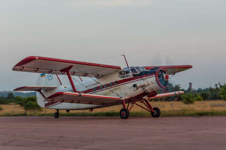 Zhitomir, Ukraine - June 18, 2011: Antonov An-2 biplane is taking off on sunset from the airstrip