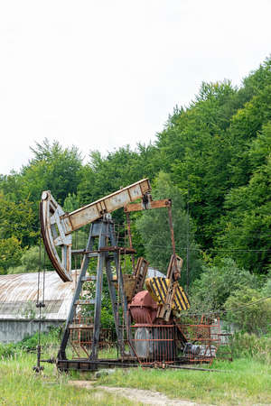 Oil rig is pumping the oil with beautiful landscape on the backgroundの写真素材