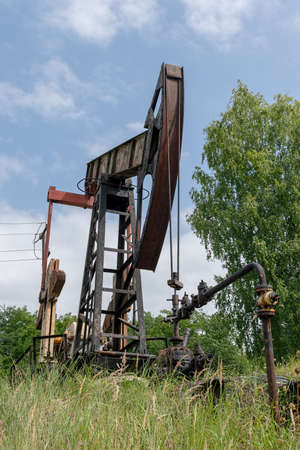Oil rig is pumping the oil with beautiful landscape on the backgroundの写真素材