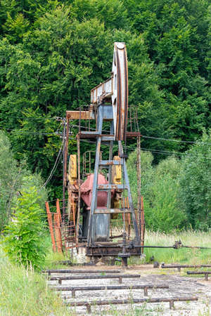 Oil rig is pumping the oil with beautiful landscape on the backgroundの写真素材