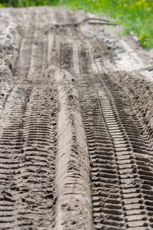 Track of a heavy truck tire on the wet ground surface