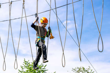Boy practicing his climbing skills in a rope parkの写真素材