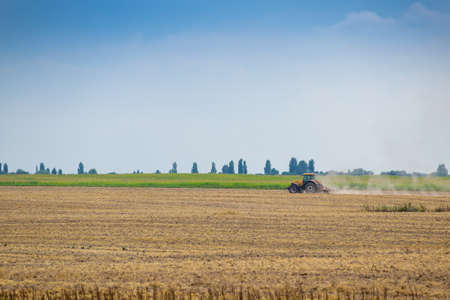 Rural landscape with tractor cultivating the fieldの写真素材