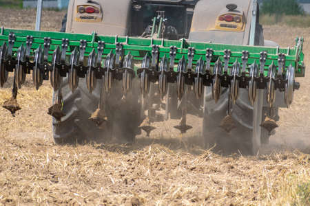 Yellow tractor with the cultivator rear view closeupの写真素材