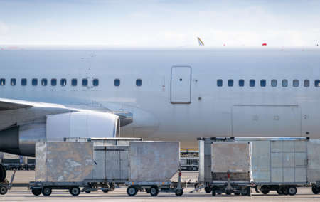 Carts with cargo containers before loading to the plane in the airportの写真素材