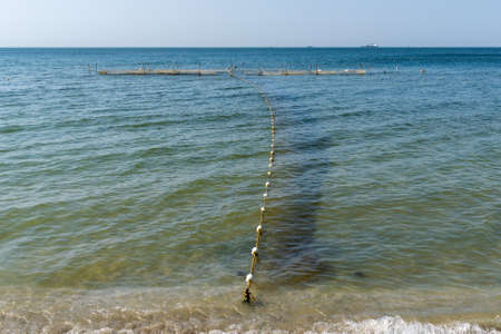Oyster farm at sea shore on a calm and sunny summer dayの写真素材