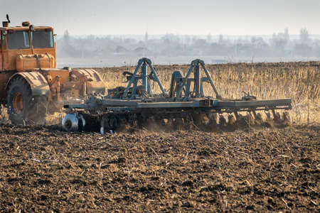 Tractor cultivating the field in rural areaの写真素材