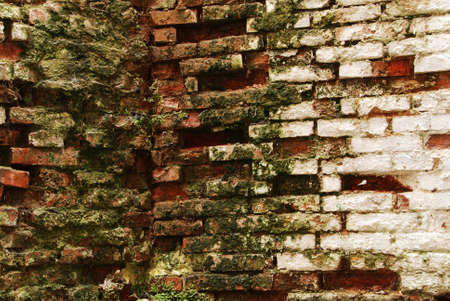 An old wall background with cracked paint and broken bricksの写真素材