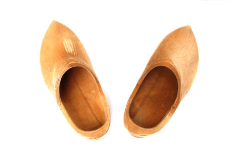 A pair of ancient wooden shoes on white の写真素材