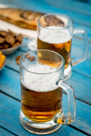 beer, fish and toasts on wooden tableの写真素材