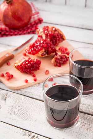 glass of pomegranate juice with fresh fruits on wooden tableの写真素材