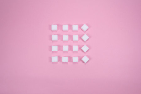 White sugar cubes on pink background composition. Minimal abstract food concept. White cubes.の写真素材