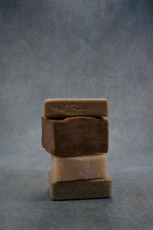 Four different color soaps on pink background composition. Minimal abstract background composition with different colors and handmade reference. With copy space.の写真素材