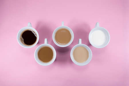 Five cups of coffee on pink background. Minimal abstract pink background concept composition with cups of coffee and milk.の写真素材