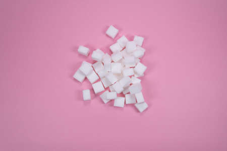 White sugar cubes on pink background composition. Minimal abstract food concept. White cubes.の写真素材