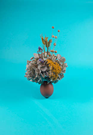 Abstract minimal modern concept composition, Easter egg with a different dried flowers and floral motives. Egg representing a vase. Flowers growing out of an egg.の写真素材