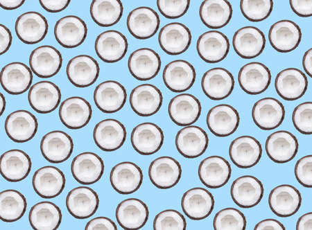 Multiplied sliced coconut half on pastel blue background. Tropical fruits. Summer concept. With copy space.の写真素材