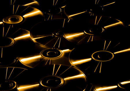 Modern abstract background. Golden shiny CDs glowing in the dark. Music and retro technology...