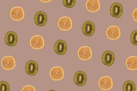 Lemon and kiwi slices multiplied on pastel brown background. Minimal healthy food, tropical fruits...