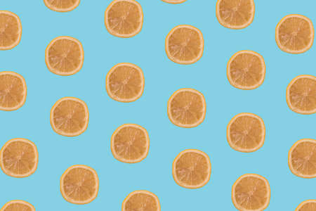 Lemon slices multiplied on trendy pastel soft blue background. Minimal 
healthy food, tropical fruits and summer concept.の写真素材