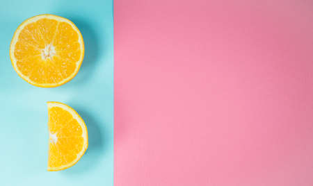 Orange slices on trendy pastel blue and pink background. Party and fun idea. Minimal summer concept.の写真素材