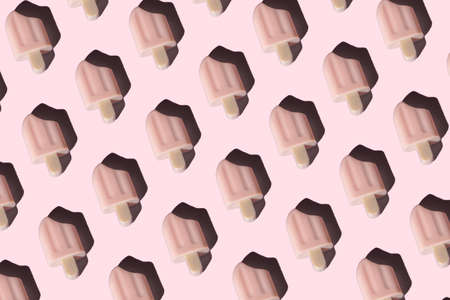 Creative layout of pink ice cream on pastel pink background. Seamless pattern with shadow. Top view. Flat lay. Minimal abstract season specific and summer concept. Copy space.の写真素材