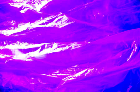 Abstract background made of ultra violet plastic bag and back lit flash light. Grunge texture. Vibrant colors. Minimal abstract background and pollution concept. With copy space.の写真素材