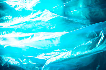 Abstract background made of blue plastic bag and back lit flash light. Grunge texture. Vibrant colors. Minimal abstract background and pollution concept. With copy space.の写真素材