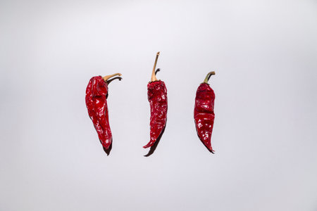 Creative layout made of three red peppers on grey background. Top view, flat lay. Minimal food and...