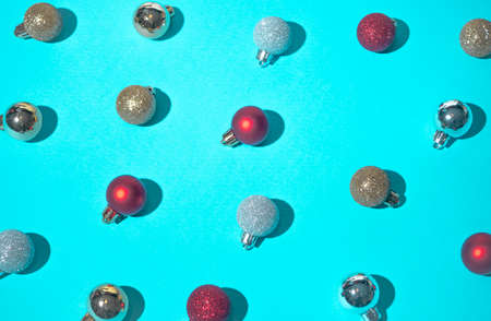 Colorful layout made of Christmas tree baubles on snowy blue background. Flat lay, top view. Minimal abstract winter holidays concept. Copy space.の写真素材