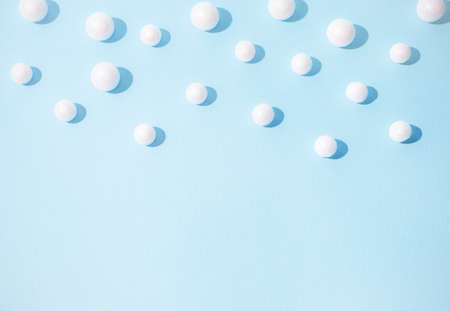 Snowballs on half of pastel blue background. New Year and Christmas idea. Minimal abstract winter holidays concept. Copy space.の写真素材