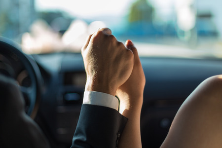 bride and groom holding hands in a car
