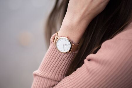 detail shot of a young fashionable business woman with golden watch on handの写真素材