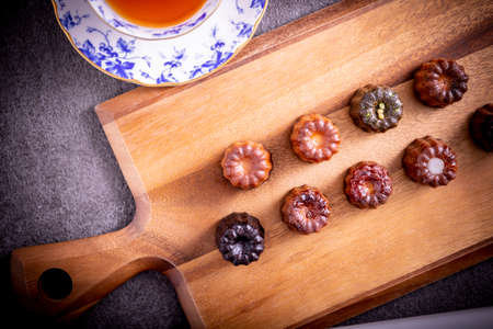 Served tea and canelÃ© on a cutting boardの写真素材